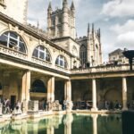 The Great Bath pool with surrounding galleries and Bath Abbey beyond